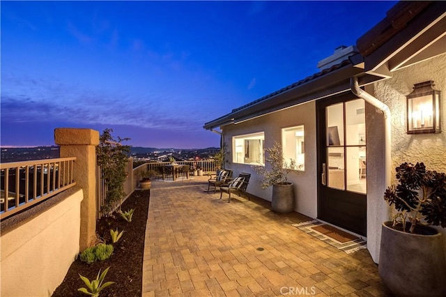 27553 Via Fortuna, San Juan Capistrano, CA 92675 - property exterior at dusk with a patio, stucco siding, and fence