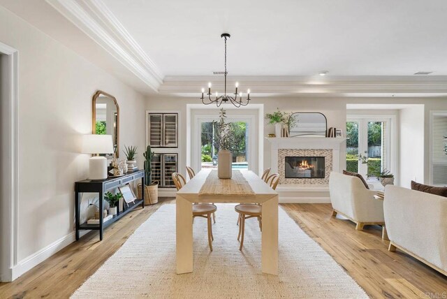 753 Jacquelene Ct, Encinitas, CA 92024 - dining room featuring a glass covered fireplace, crown molding, a chandelier, light wood finished floors, and baseboards