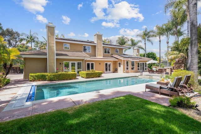 753 Jacquelene Ct, Encinitas, CA 92024 - rear view of property featuring french doors, solar panels, a patio, an outdoor pool, and a chimney