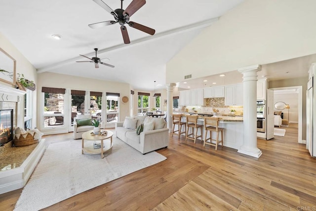 753 Jacquelene Ct, Encinitas, CA 92024 - living area featuring a ceiling fan, a glass covered fireplace, decorative columns, light wood-style flooring, and high vaulted ceiling