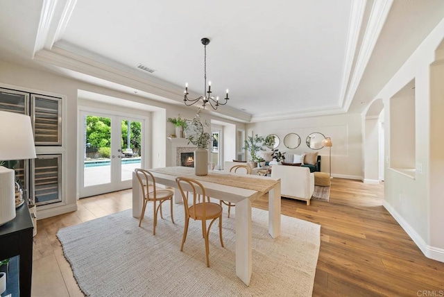 753 Jacquelene Ct, Encinitas, CA 92024 - dining area featuring a tray ceiling, a chandelier, french doors, crown molding, and wood finished floors