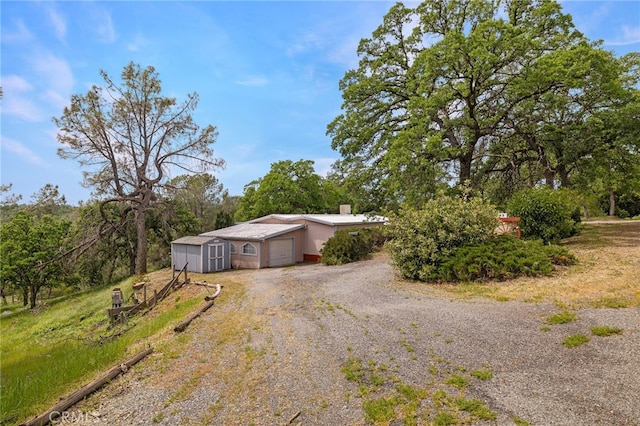 7395 Cardinal Rd, Corning, CA 96021 - view of front of house with a storage shed, driveway, a chimney, and a garage