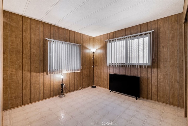 spare room featuring wood walls and tile patterned floors