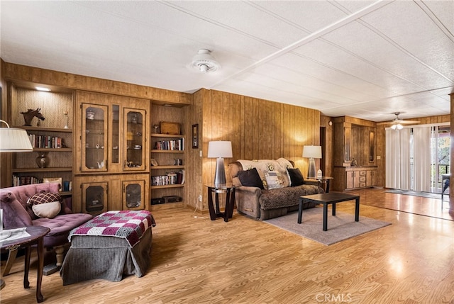 living area featuring wood walls and light wood-style floors