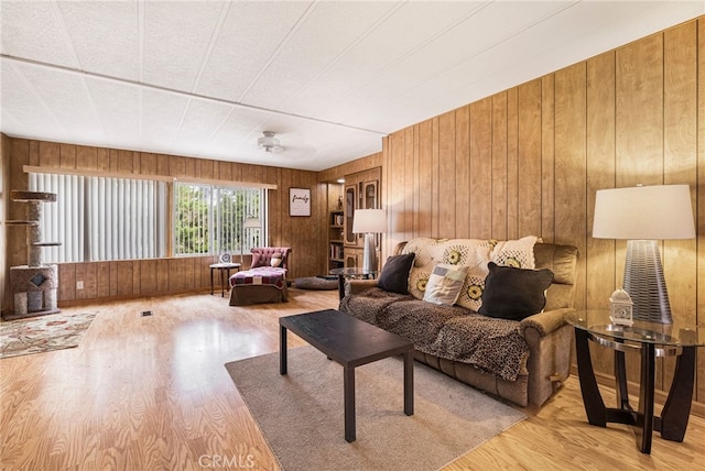living area with wooden walls and wood finished floors