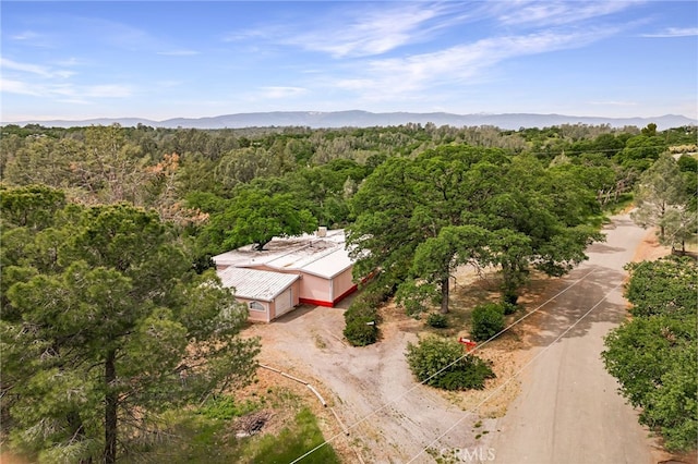 birds eye view of property featuring a wooded view and a mountain view