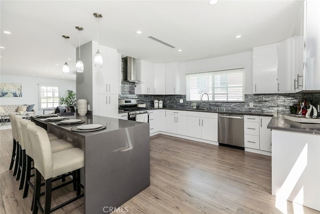 1430 Irving Ave, Glendale, CA 91201 - kitchen with tasteful backsplash, white cabinets, wall chimney exhaust hood, dark countertops, and appliances with stainless steel finishes