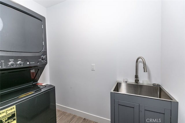 1430 Irving Ave, Glendale, CA 91201 - washroom with a sink, light wood-style flooring, stacked washer and dryer, and baseboards