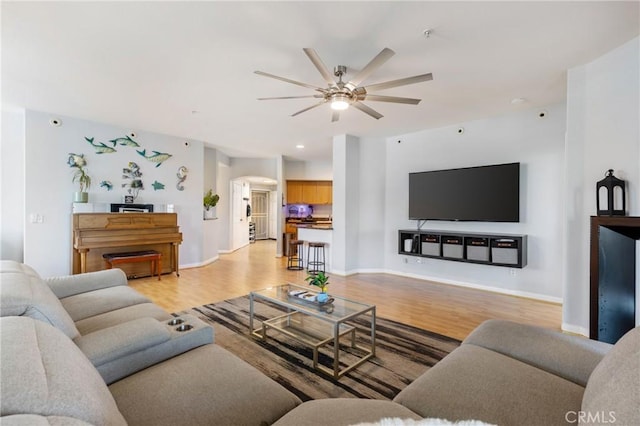1180 Civic Center Dr Unit B21, Oceanside, CA 92054 - living area featuring arched walkways, ceiling fan, light wood-style flooring, and baseboards