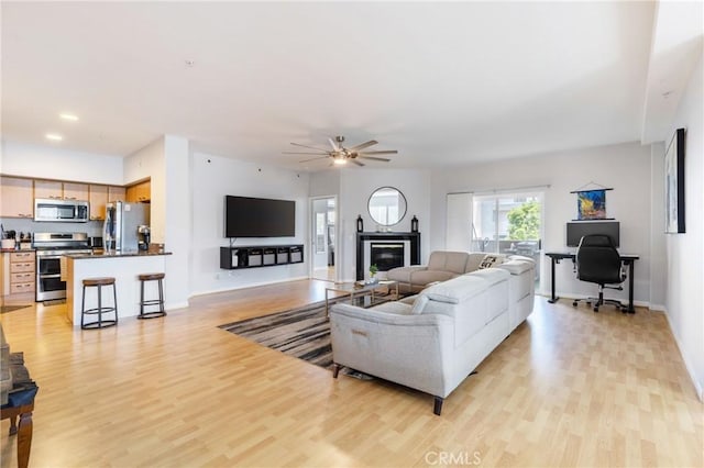 1180 Civic Center Dr Unit B21, Oceanside, CA 92054 - living area featuring light wood-style flooring, a ceiling fan, baseboards, and a glass covered fireplace