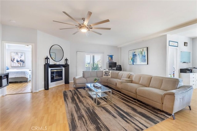 1180 Civic Center Dr Unit B21, Oceanside, CA 92054 - living area featuring light wood-style flooring, ceiling fan, and a glass covered fireplace