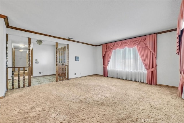 unfurnished room featuring baseboards, visible vents, carpet floors, and crown molding