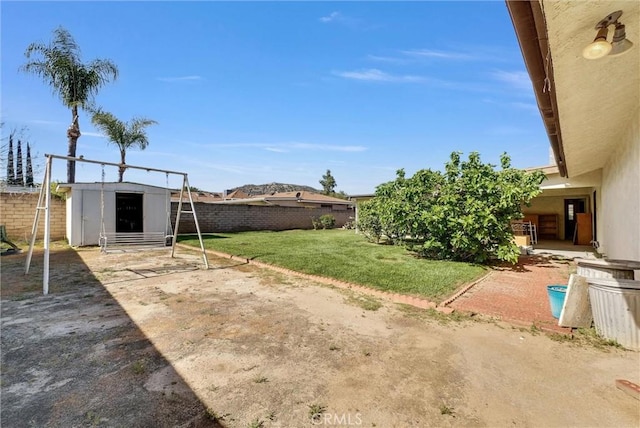 view of yard with a fenced backyard, an outbuilding, a patio area, and a storage shed