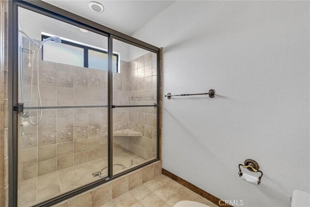 full bathroom featuring baseboards, tile patterned floors, and a stall shower