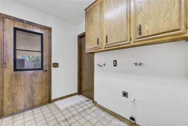 laundry area featuring baseboards, cabinet space, light floors, electric dryer hookup, and gas dryer hookup