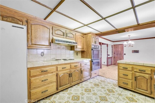 kitchen featuring tile counters, white appliances, an inviting chandelier, under cabinet range hood, and visible vents