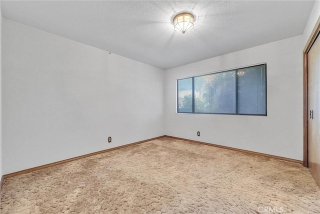 carpeted empty room with baseboards