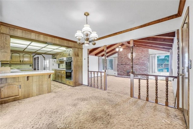 kitchen featuring light carpet, plenty of natural light, double wall oven, an inviting chandelier, and tile counters