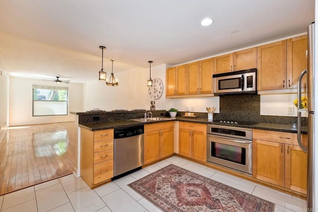 1150 J St Unit 117, San Diego, CA 92101 - kitchen with stainless steel appliances, a peninsula, a sink, decorative light fixtures, and tasteful backsplash