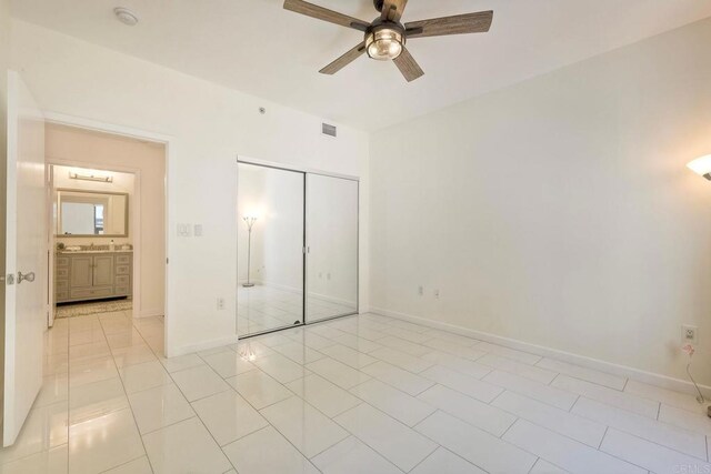 1150 J St Unit 117, San Diego, CA 92101 - unfurnished bedroom with a closet, light tile patterned floors, baseboards, and ceiling fan