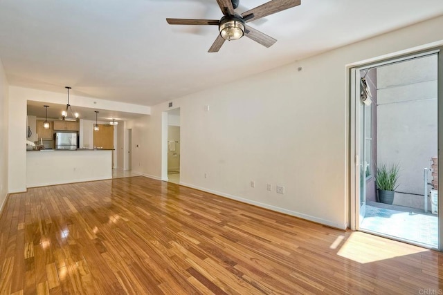 1150 J St Unit 117, San Diego, CA 92101 - unfurnished living room with light wood-type flooring, a ceiling fan, and baseboards