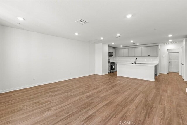 4265 S Hermosa Paseo, Ontario, CA 91761 - unfurnished living room featuring recessed lighting, visible vents, light wood-type flooring, and a sink