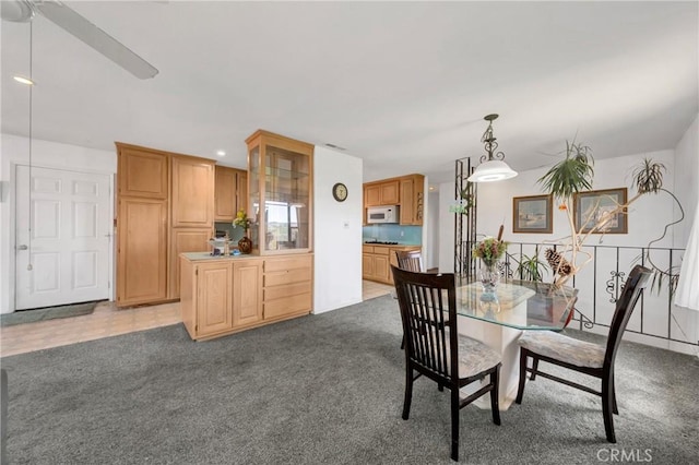 dining space with light carpet and a ceiling fan
