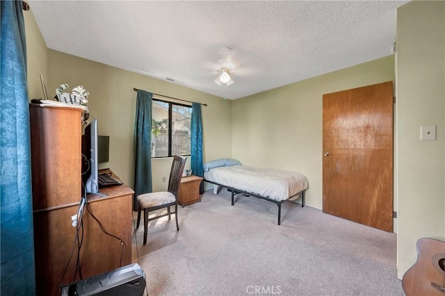bedroom featuring ceiling fan, a textured ceiling, visible vents, and carpet floors