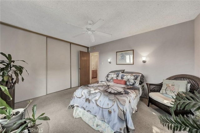 carpeted bedroom featuring a closet, a ceiling fan, and a textured ceiling