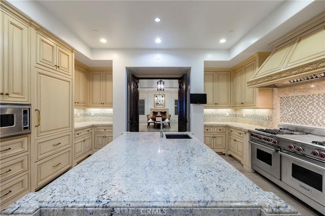 2258 Channel Rd, Newport Beach, CA 92661 - kitchen with cream cabinetry, appliances with stainless steel finishes, a sink, custom range hood, and light stone countertops