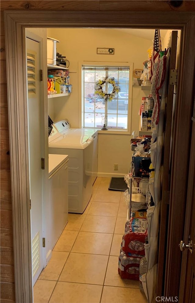 laundry area featuring separate washer and dryer, laundry area, and light tile patterned flooring