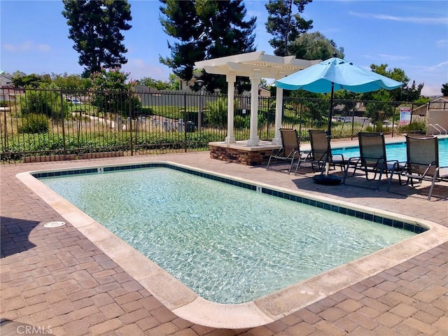 community pool with a patio area, fence, and a pergola