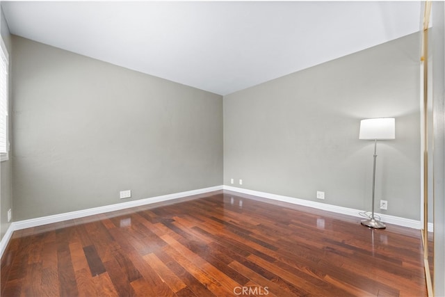 unfurnished room with baseboards and wood finished floors