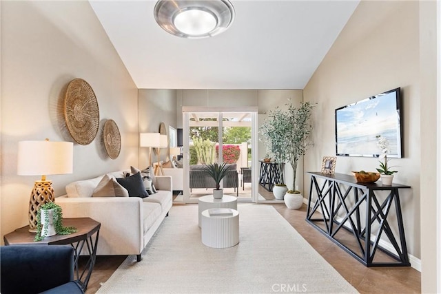 living area featuring baseboards and vaulted ceiling