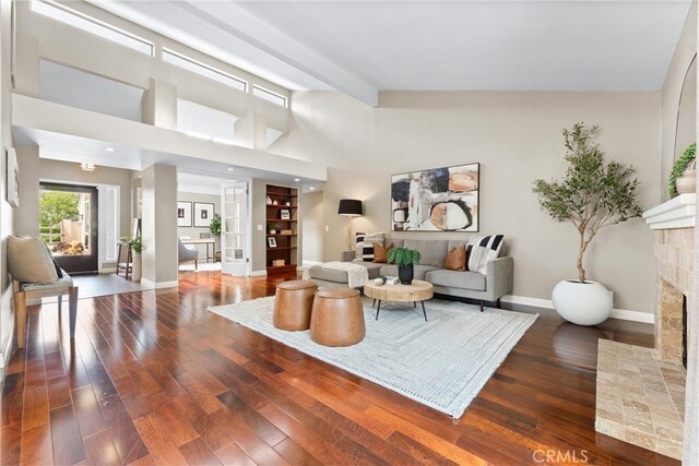 living area featuring baseboards, wood finished floors, and a fireplace