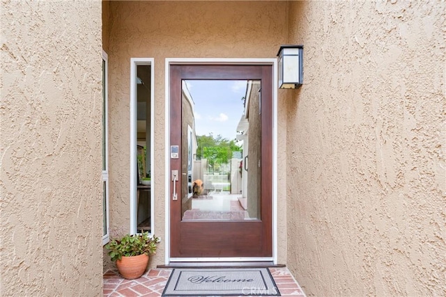 view of exterior entry featuring stucco siding