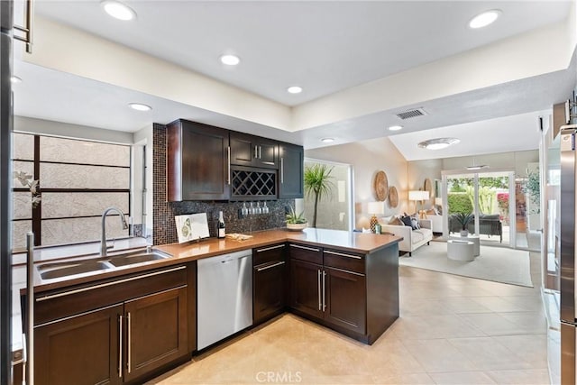bar featuring a sink, stainless steel appliances, light tile patterned floors, backsplash, and visible vents