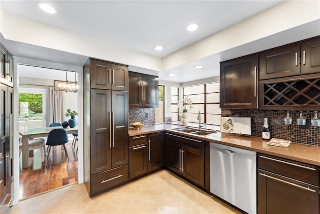kitchen featuring plenty of natural light, a sink, backsplash, and dishwasher