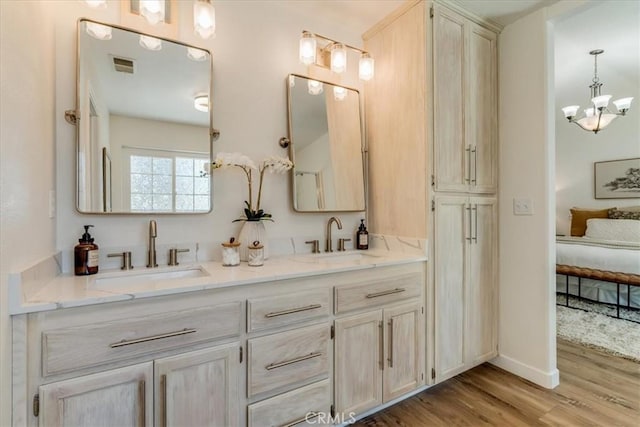 ensuite bathroom with ensuite bath, visible vents, a sink, and wood finished floors