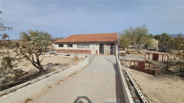 mediterranean / spanish-style home featuring stucco siding, stone siding, and a tile roof