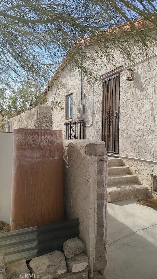 exterior space with entry steps and stucco siding