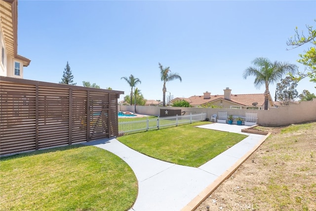 view of yard with a fenced backyard, a fenced in pool, and a patio