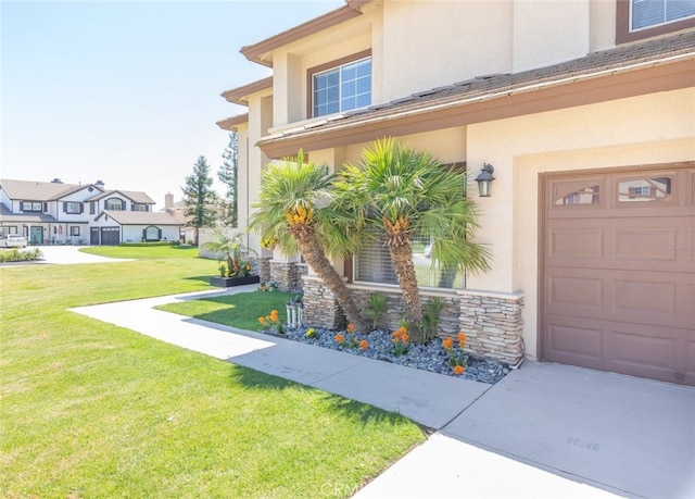 doorway to property with driveway, a garage, a lawn, and stucco siding