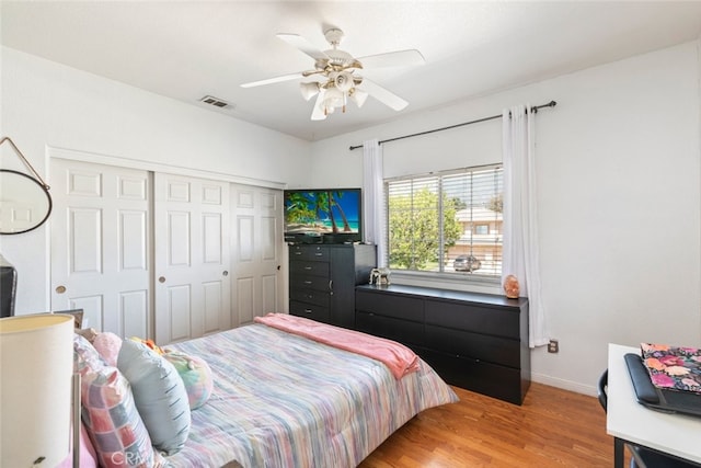 bedroom with ceiling fan, light wood-style flooring, a closet, visible vents, and baseboards