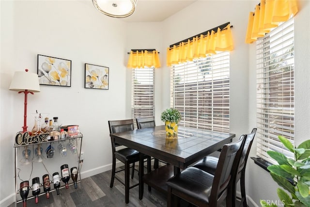 dining area with dark wood-type flooring and baseboards