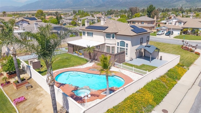 view of swimming pool with a residential view, a mountain view, a patio area, a fenced backyard, and a lawn
