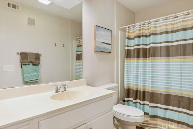 bathroom featuring visible vents, toilet, a shower with curtain, and vanity