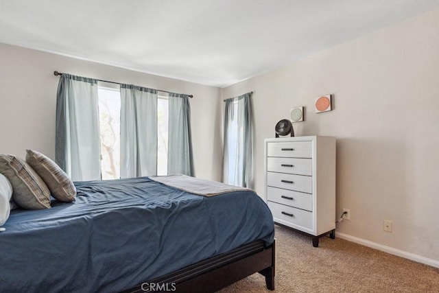 bedroom with light carpet and baseboards