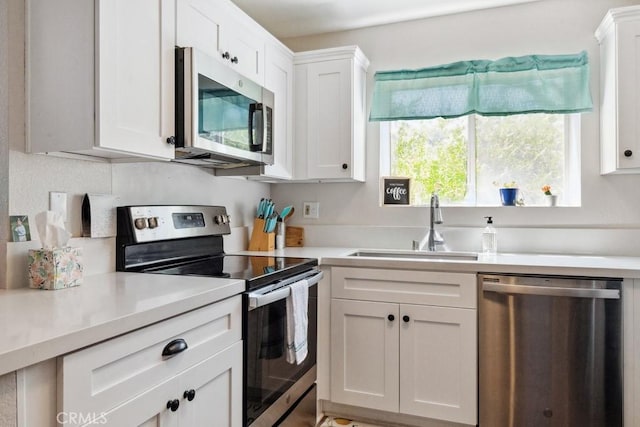 kitchen featuring white cabinets, appliances with stainless steel finishes, and a sink