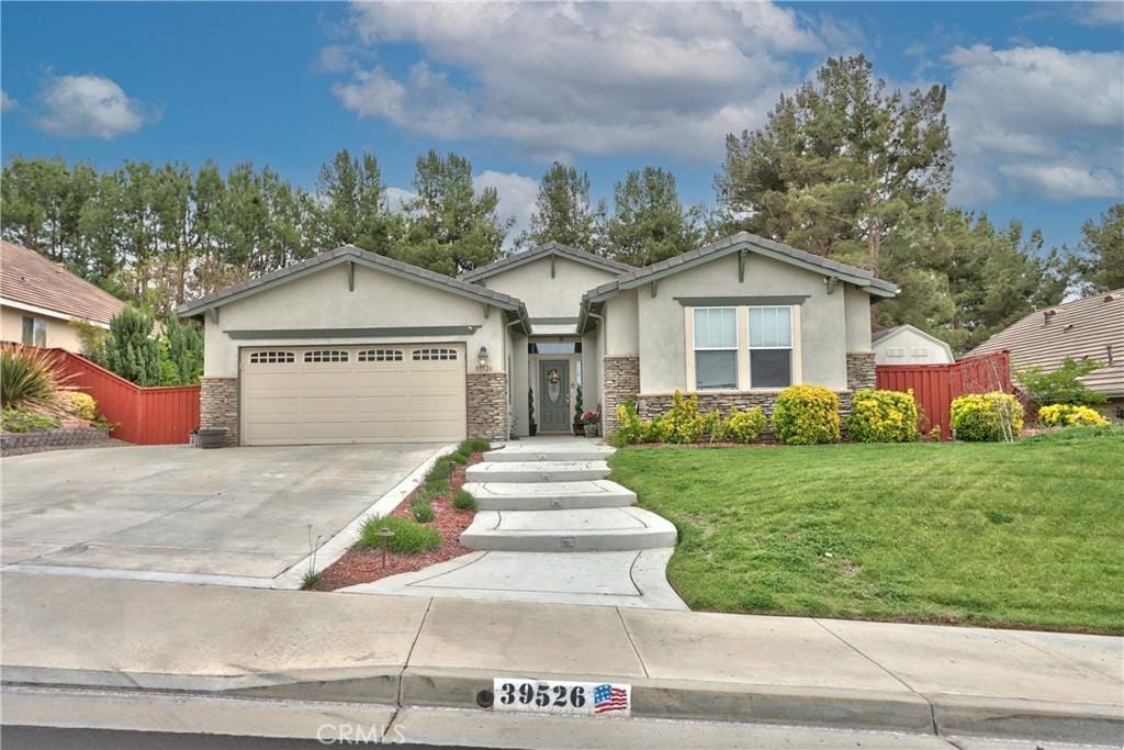 39526 Sierra Madre Dr, Murrieta, CA 92563 - view of front of home featuring fence, an attached garage, stucco siding, and stone siding